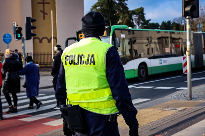 Policjant tyłem w kamizelce odblaskowej nadzoruje ruch. W tle autobus BKM. O zmianach drogowych pisze SE Białystok.