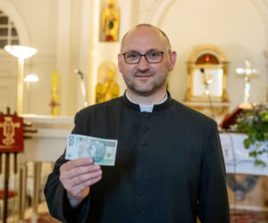 Ksiądz rozdaje pieniądze na mszy