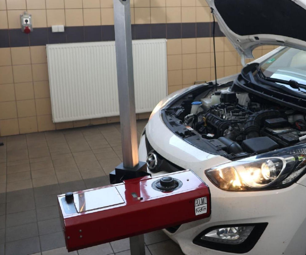 Białe auto z otwartą maską podczas kontroli świateł urządzeniem diagnostycznym. O akcji w powiecie kieleckim pisze Eska Kielce.