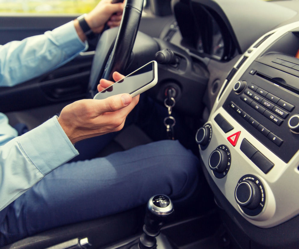 ZAKAZ używania telefonów komórkowych podczas jazdy samochodem. Nie odpalisz z niego nawet muzyki!