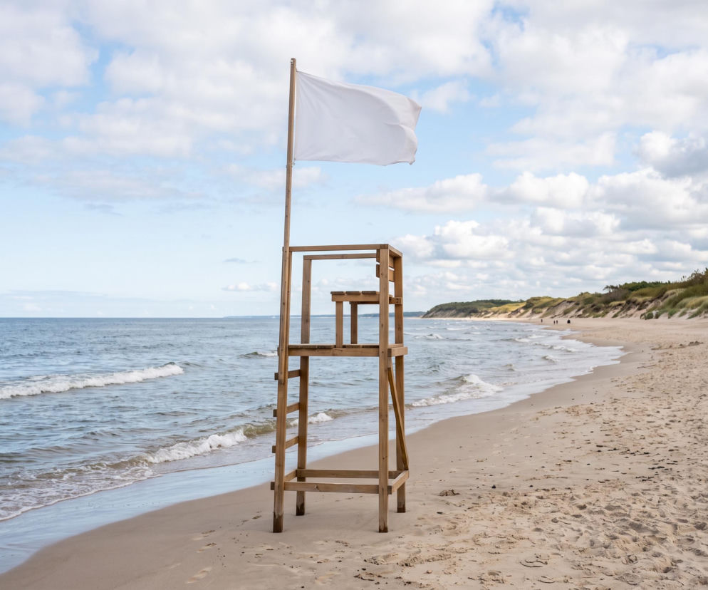 Biała flaga na wieży ratowniczej na plaży w Międzyzdrojach. O bezpieczeństwie nad wodą przeczytasz na SE Szczecin.
