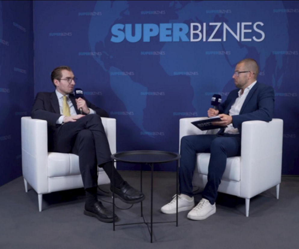 Wiceminister funduszy i polityki regionalnej Jan Szyszko w garniturze i krawacie udzielający wywiadu Łukaszowi Trybulskiemu z Super Biznesu. Obaj mężczyźni siedzą w fotelach, na tle ściany z logo portalu Super Biznes. Rozmowa dotyczy programu Czyste Powietrze oraz planów podniesienia progu podatkowego.