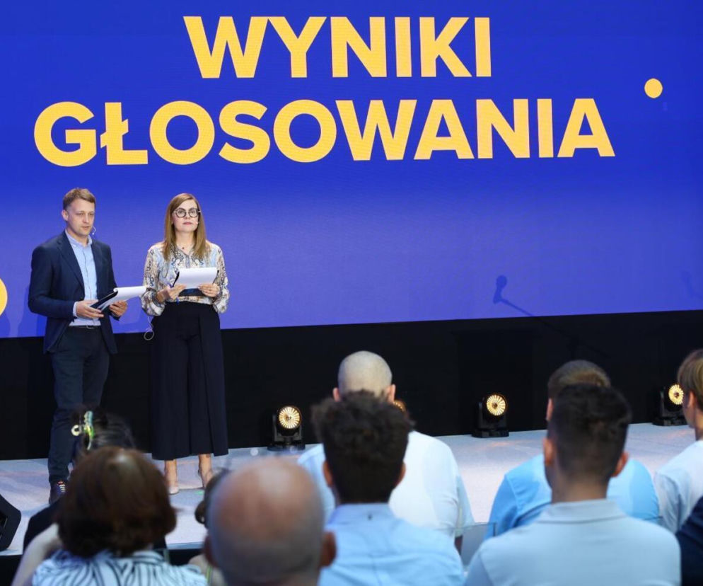 Dwie osoby prezentują wyniki głosowania na scenie w Warszawie. O kryzysie frekwencji przeczytasz na SE.