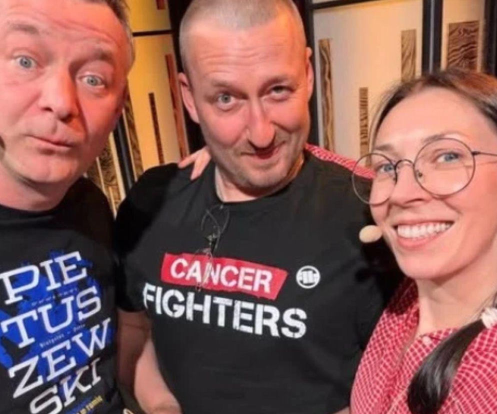 Uśmiechnięty Tomasz Marciniak w koszulce Cancer Fighters z Kabaretem Nowaki. O powrocie artysty przeczytasz na Eska.