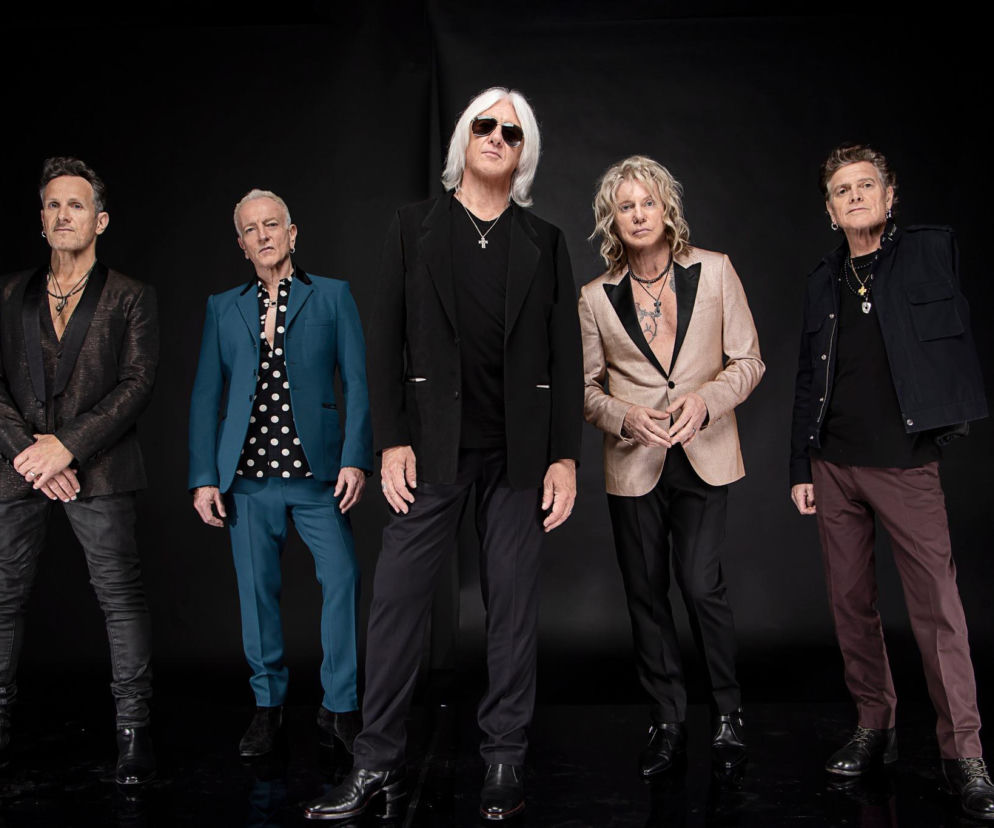 Muzycy zespołu Def Leppard pozują na czarnym tle. O nowym filmie dokumentalnym grupy przeczytasz na EskaRock.