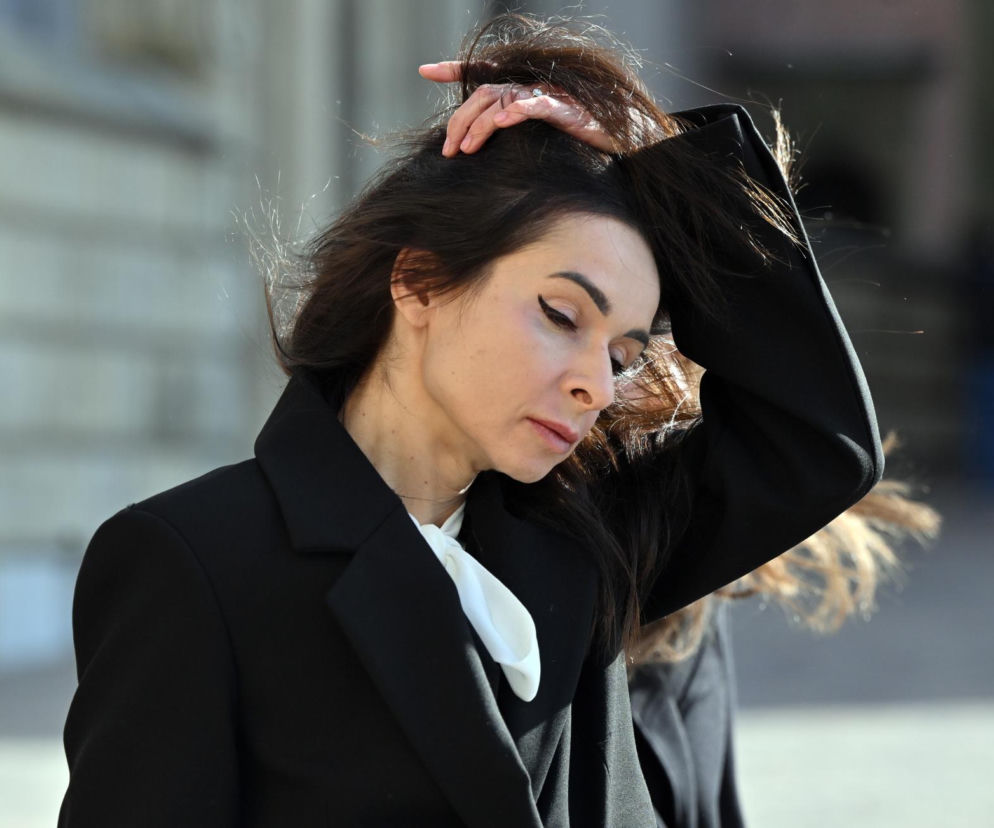Marta Kaczyńska w ciemnym płaszczu poprawia dłonią włosy. O jej tajemniczych zdjęciach przeczytasz w SE.