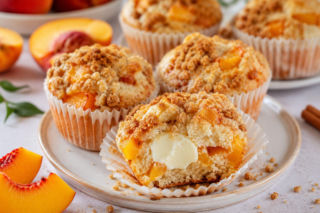 Muffinki brzoskwiniowe z kruszonką skrywają kremowy środek. Małe smakołyki na jeden kęs