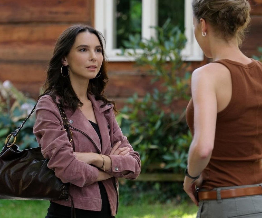 Aktorka Marcelina Kieres jako Paula i Dominika Suchecka jako Natalka z serialu M jak miłość. Paula ma na sobie różową ramoneskę i ciemną torebkę, Natalka odwrócona jest tyłem. Więcej o ich relacji dowiesz się na Super Seriale.