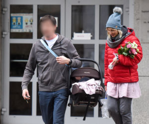 Joanna Moro z mężem i dzieckiem wychodzą po porodzie ze szpitala