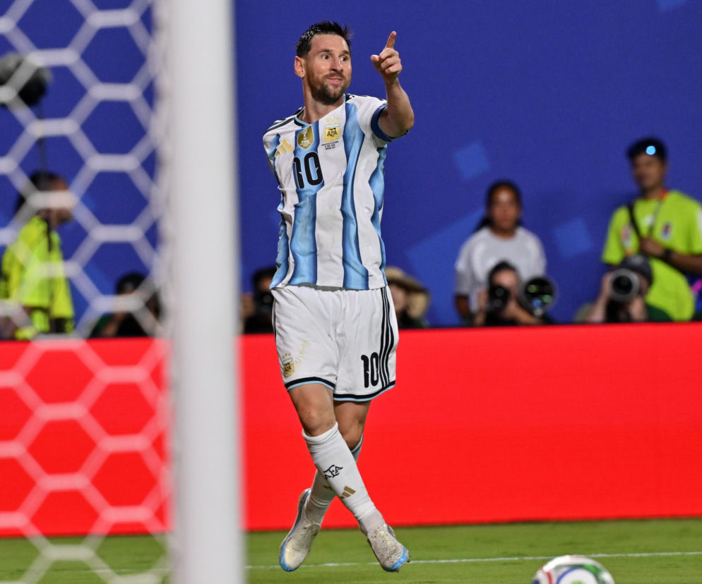 Piłkarz Lionel Messi w koszulce Argentyny z numerem 10, wskazujący palcem w górę po zdobyciu gola, na tle siatki bramkowej i kibiców. Emocje sportowe z Mistrzostw Świata 2026, o których przeczytasz więcej na naszym portalu.