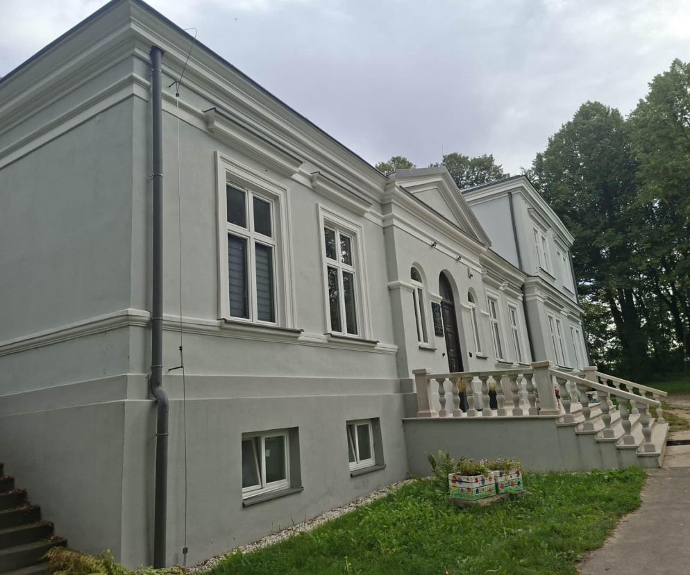 Jasnoszary dworek w Chocimowie z ozdobną balustradą i schodami. O historii wsi przeczytasz na Eska Kielce.