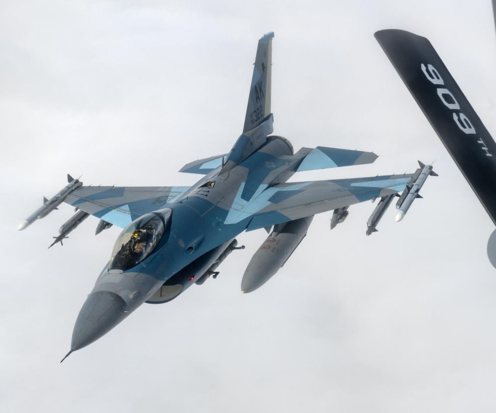 Amerykański myśliwiec F-16 w locie na tle jasnego nieba. O ochronie Donalda Trumpa przeczytasz na SE Portal Obronny.