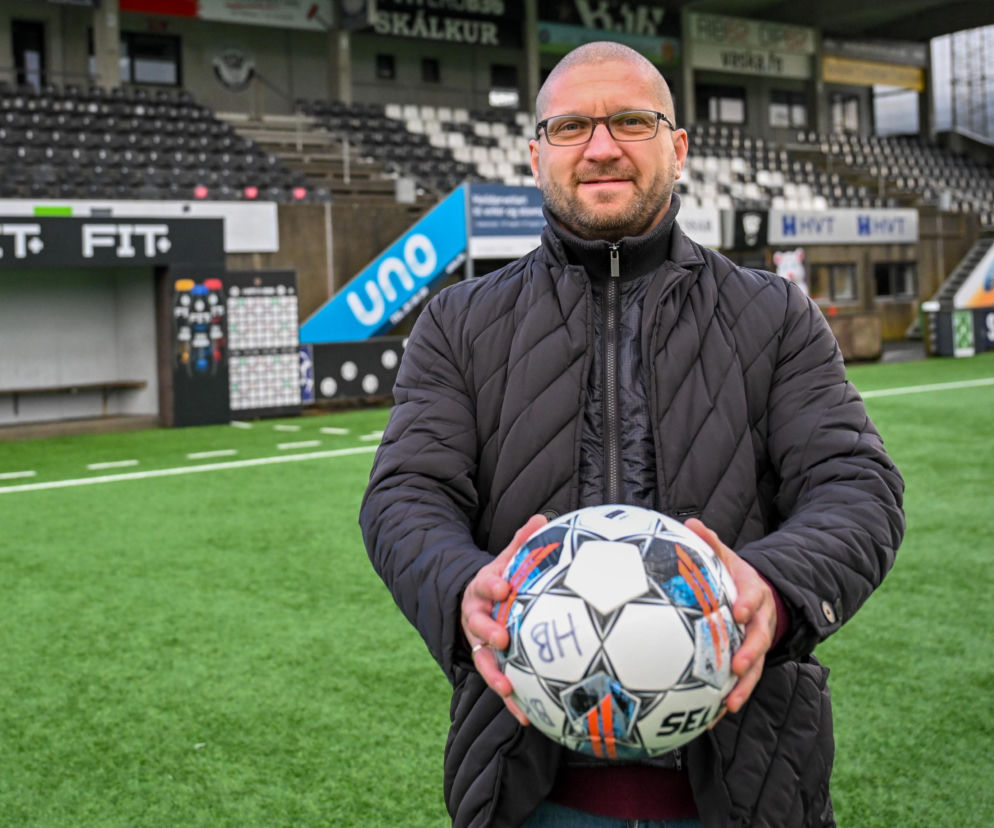 Trener Łukasz Cieślewicz trzyma piłkę na tle stadionu. O szansach Lecha Poznań z KI Klaksvik przeczytasz na SE Supersport.