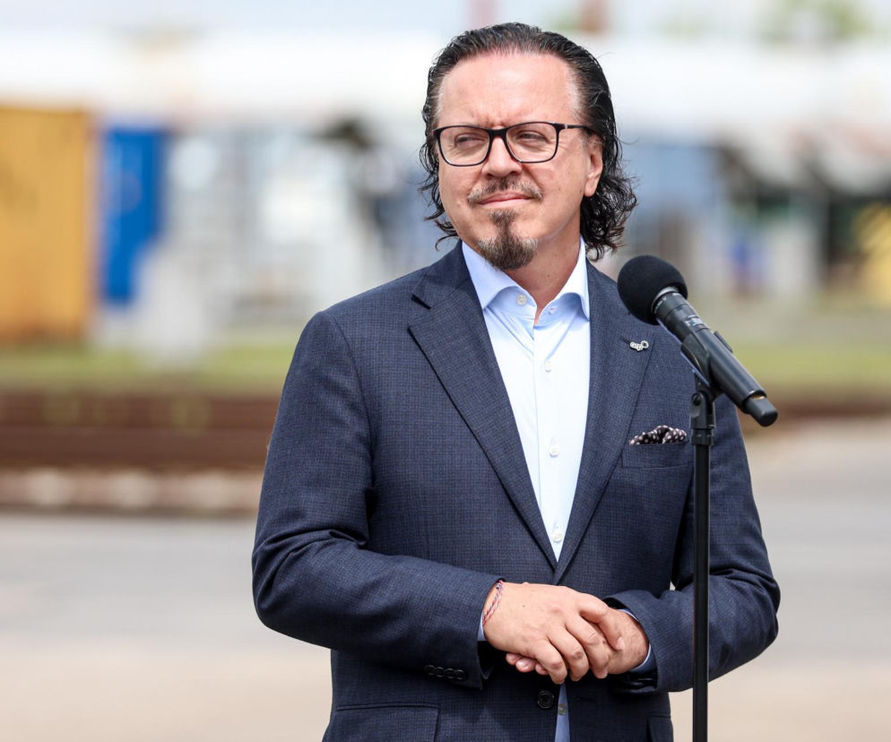 Minister Wojciech Balczun w okularach stoi przy mikrofonie. O jego sporze z prezydentem przeczytasz na SE Polityka.