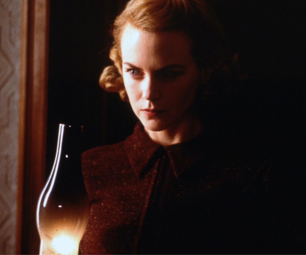 Aktorka Nicole Kidman jako Grace w filmie Inni trzyma lampę naftową. O premierze horroru przeczytasz na EskaRock.