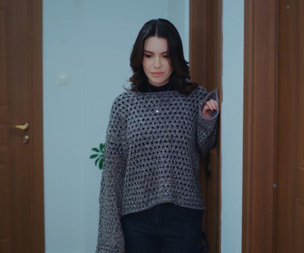 Pelin w szarym swetrze stoi w drzwiach i knuje podstęp. O jej planach w serialu Dziedzictwo czytaj w SE Superseriale.