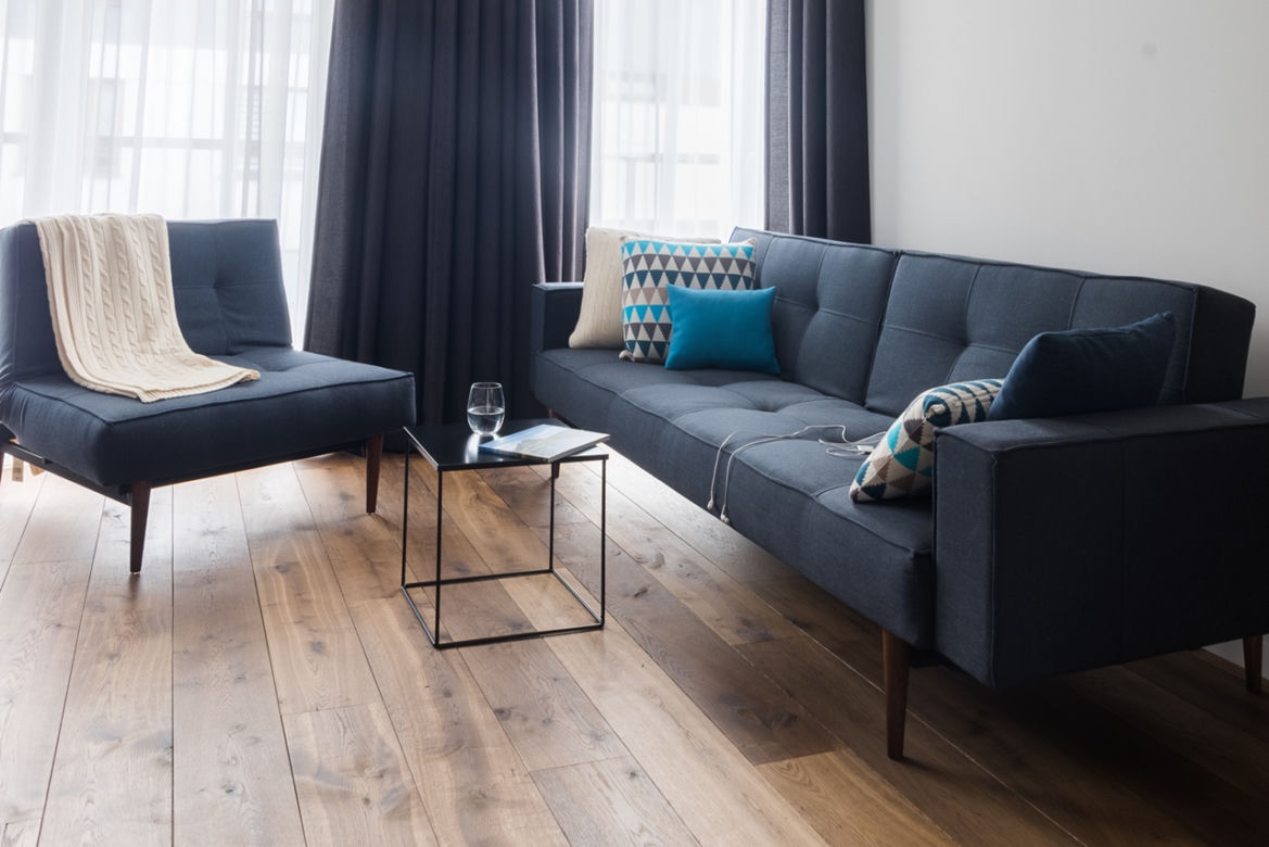 Szara sofa w salonie w stylu industrialnym