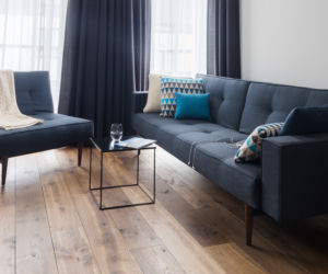 Szara sofa w salonie w stylu industrialnym