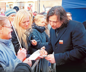 Rozdaje autografy pod Pałacem