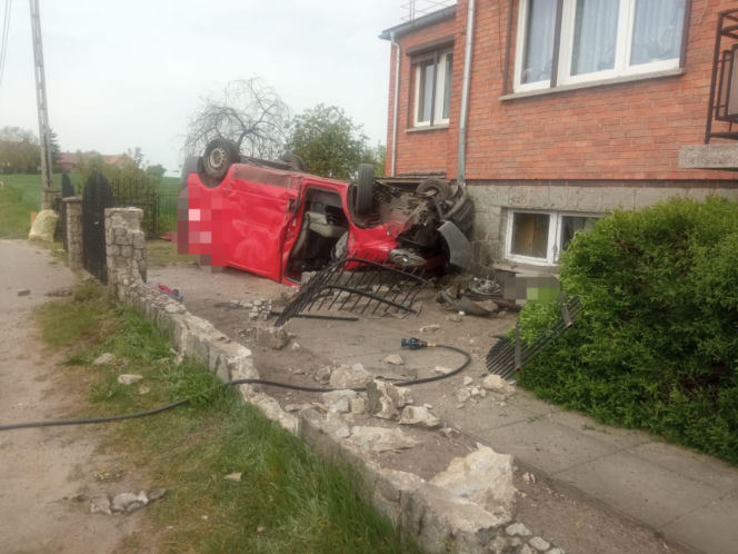 Pijany kierowca dachował busem na posesji. Zatrzymał się na elewacji domu