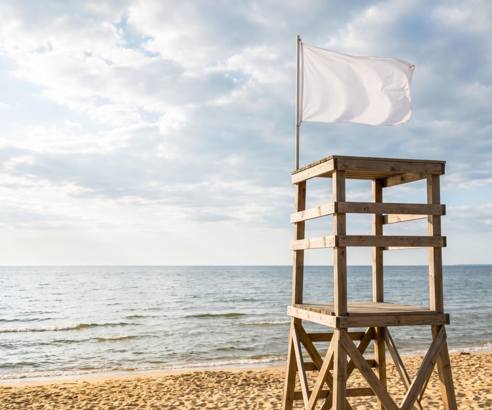 Drewniana wieża ratownika z białą flagą na plaży w Grzybowie. O warunkach kąpieli przeczytasz na SE Szczecin.
