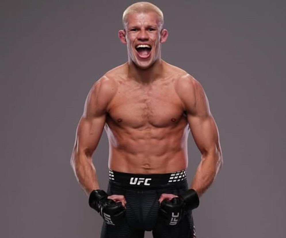 Uśmiechnięty zawodnik UFC Jakub Wikłacz z zaciśniętymi pięściami. O jego występie na MŚ przeczytasz na SE Supersport.