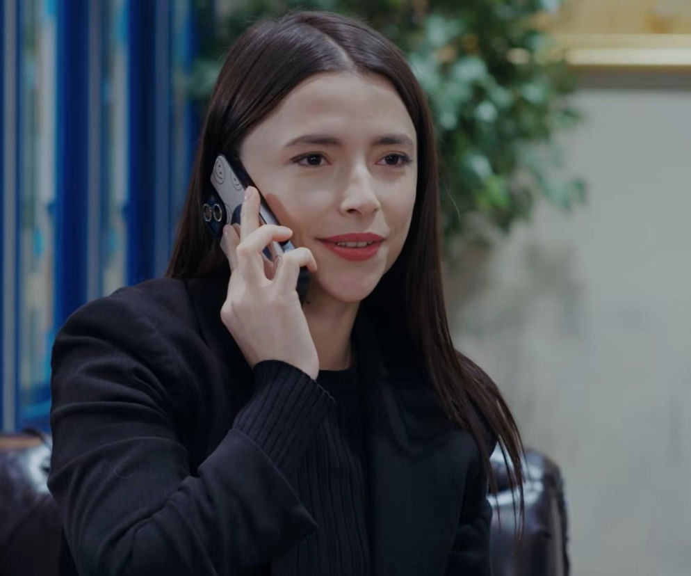 Uśmiechnięta Ezgi z serialu Dziedzictwo rozmawia przez telefon. O jej radości przeczytasz na SE Superseriale.