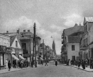Ulica w Białymstoku. Widoczne szyldy sklepów i przechodnie. Rok: 1918 - 1939