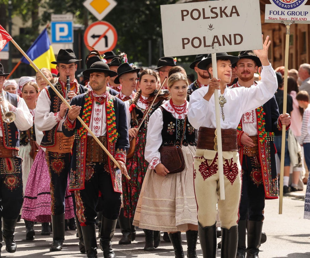 Pochód grupy folklorystycznej w strojach ludowych w Zakopanem. O magii festiwalu przeczytasz na Eska Kraków.