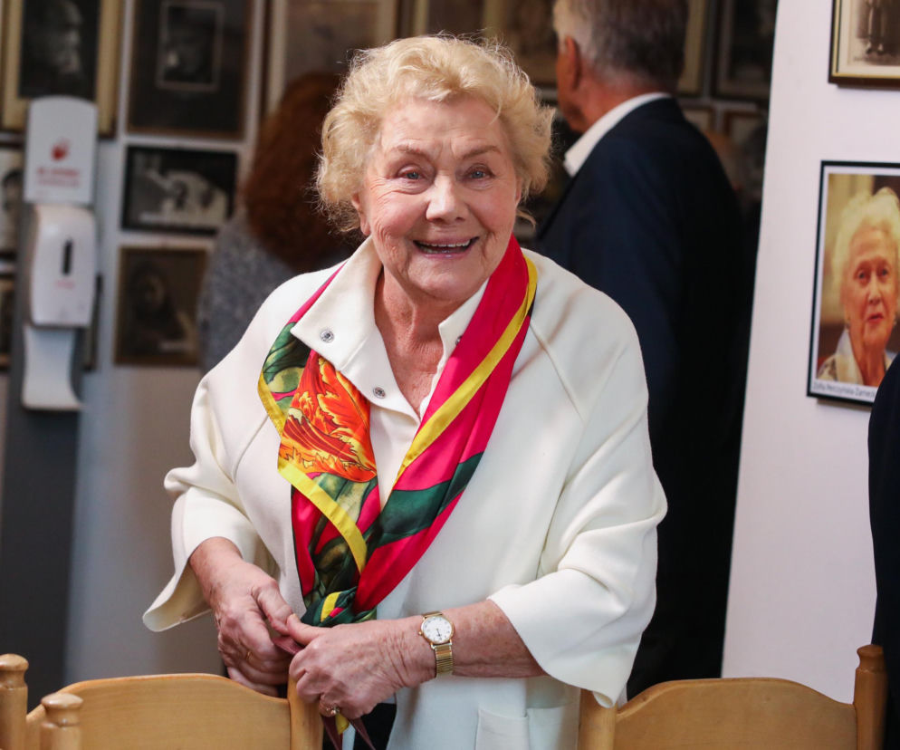 Uśmiechnięta Teresa Lipowska w jasnym płaszczu i kolorowej apaszce. O naturalności aktorki przeczytasz na SE.
