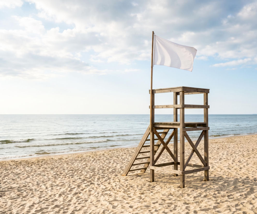 Drewniana wieża ratownika z białą flagą na plaży we Władysławowie. O czystości wody przeczytasz na Eska Trójmiasto.