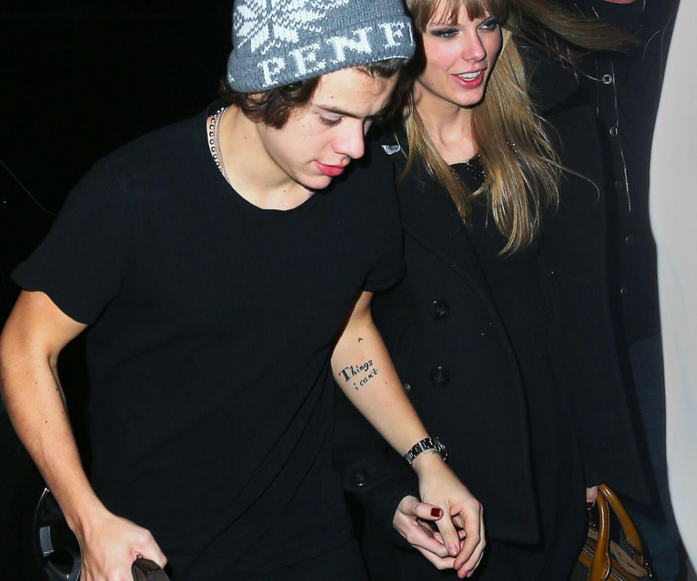 Piosenkarka Taylor Swift i Harry Styles, gwiazdor One Direction, wychodzą razem. Taylor ma na sobie czarny płaszcz i beżową torebkę, a Harry dzierży brązową torbę i nosi szarą czapkę. O ich głośnym romansie i innych partnerach Taylor przeczytasz więcej na naszym portalu.