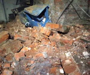 Runął zabytkowy mur na Bednarskiej. Uszkodził kilka aut i kontenery śmietnikowe
