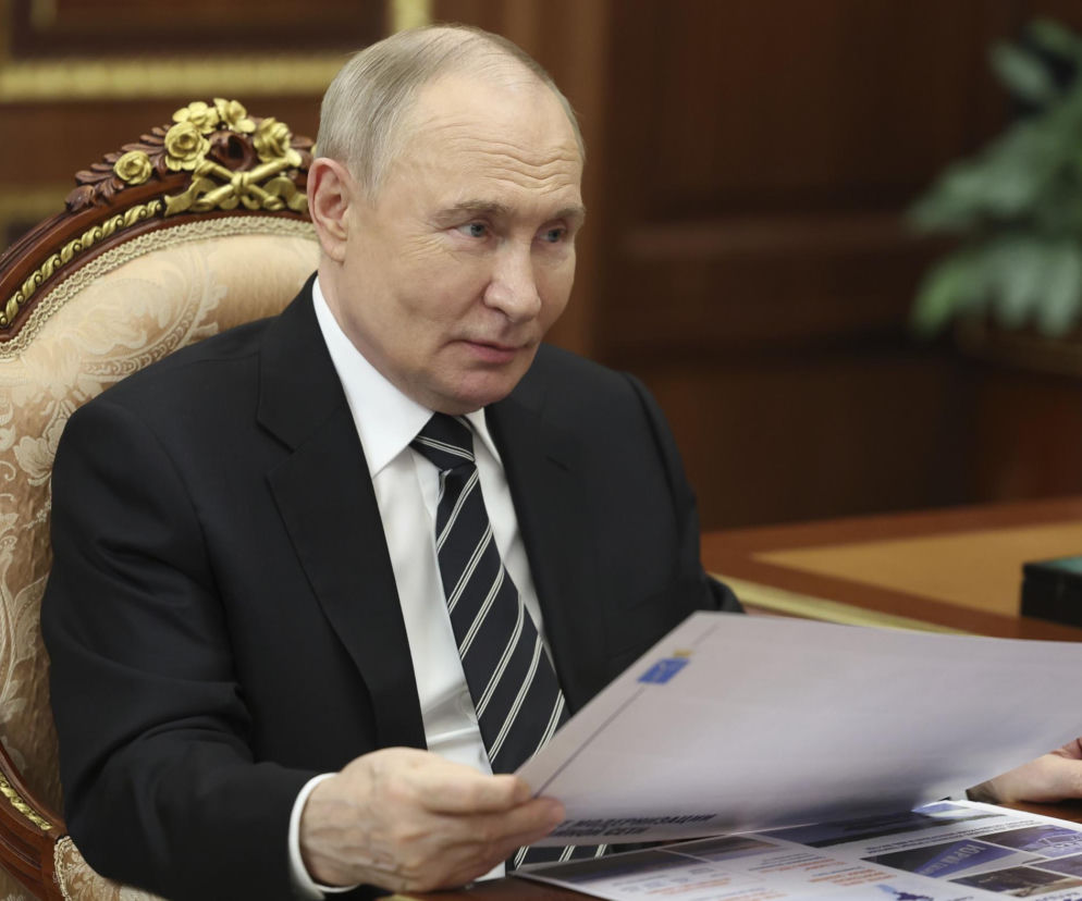Prezydent Rosji Władimir Putin siedzi przy biurku i przegląda dokumenty. O groźbach ataku na NATO przeczytasz w Eska.