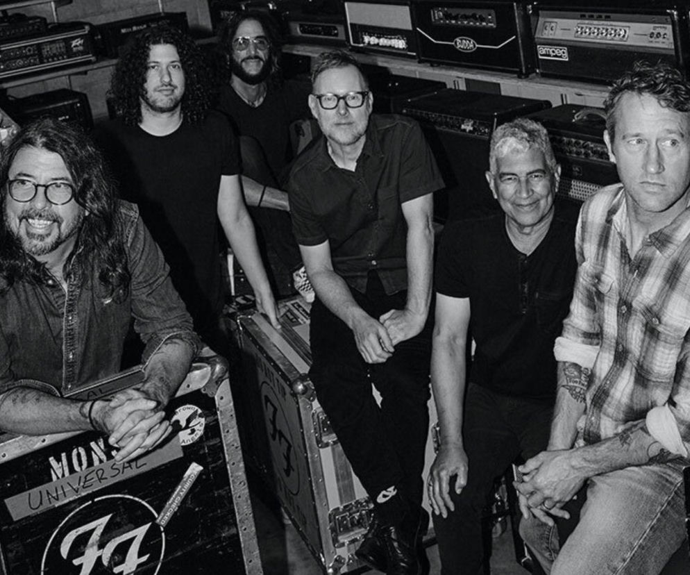Muzycy zespołu Foo Fighters na czarno-białym zdjęciu w otoczeniu sprzętu muzycznego. O zespole przeczytasz na EskaRock.