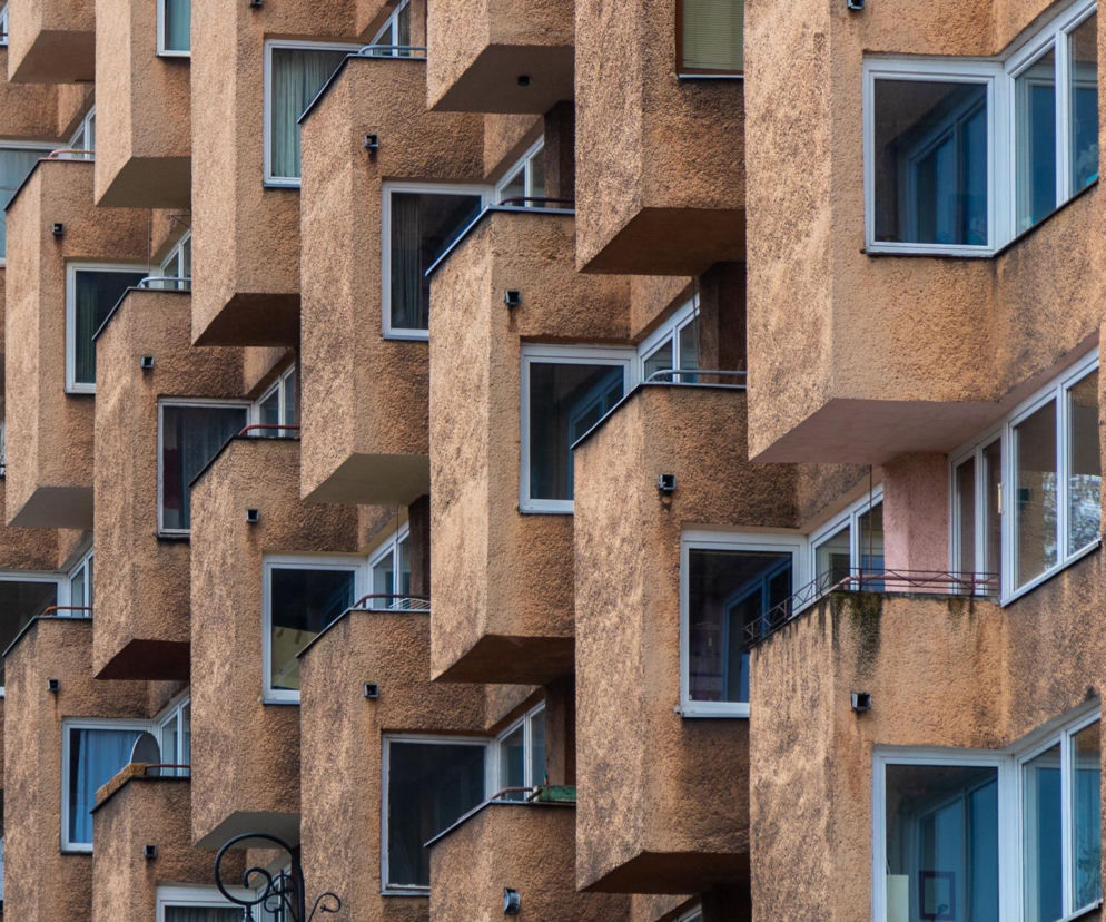 Fasada bloku mieszkalnego z PRL-u w Warszawie, z charakterystycznymi, wystającymi balkonami i oknami. Architektura Murator Plus prezentuje quiz o tych budynkach, które do dziś wyróżniają się na tle innych.