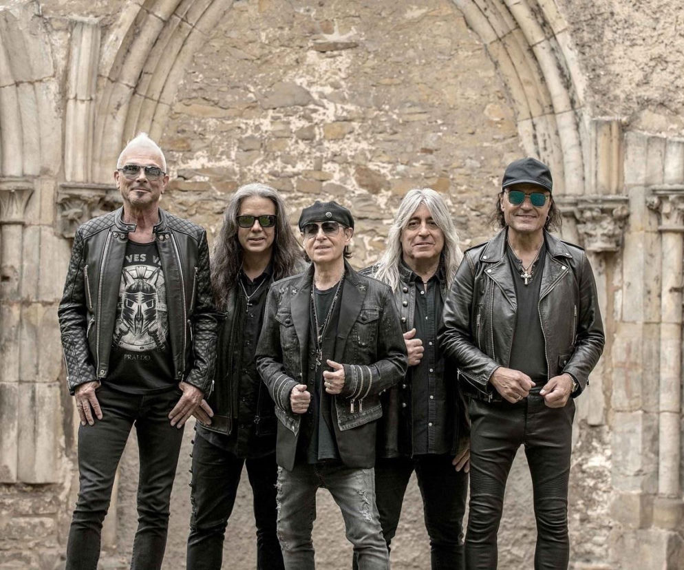Muzycy zespołu Scorpions pozujący na tle kamiennych ruin. O odwołanych koncertach przeczytasz na EskaRock.