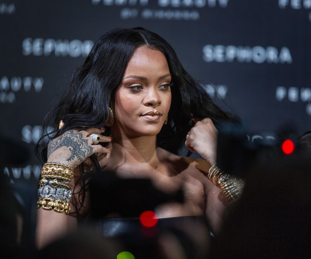 Piosenkarka Rihanna na tle logotypów Sephora. O ataku na dom artystki i jej rodziny przeczytasz w serwisie Eska.