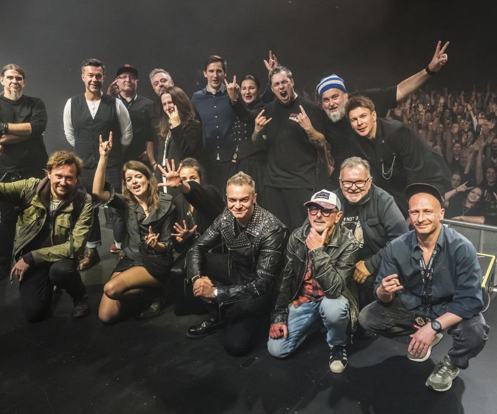 Duża grupa uśmiechniętych ludzi na scenie podczas Rocktoberfest 2026. O urodzinach radia przeczytasz na EskaRock.