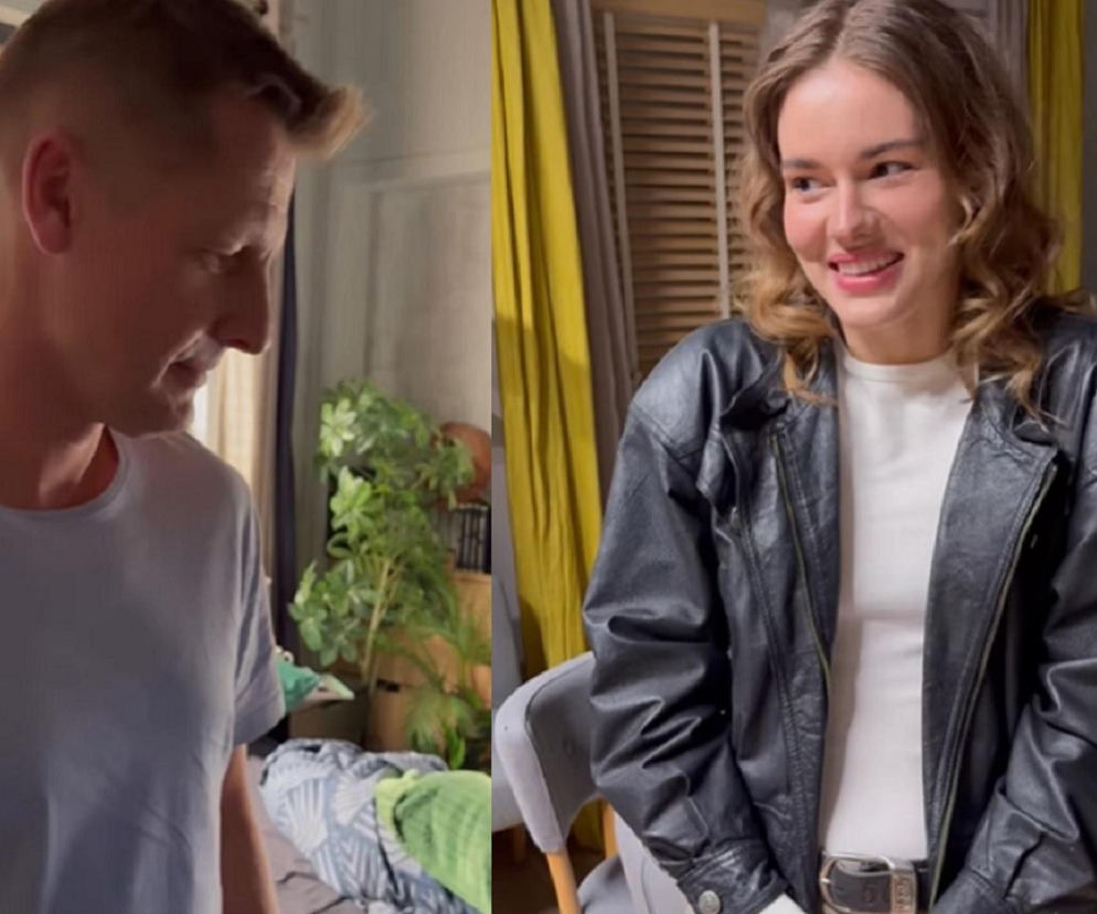 Aktorka Dominika Kachlik w czarnej skórzanej kurtce i białym T-shircie uśmiecha się, patrząc w prawo, obok niej fragment sylwetki mężczyzny. Zdjęcie przedstawia scenę z serialu M jak miłość, o dalszych losach Pawła po śmierci Franki można przeczytać na portalu Super Seriale.