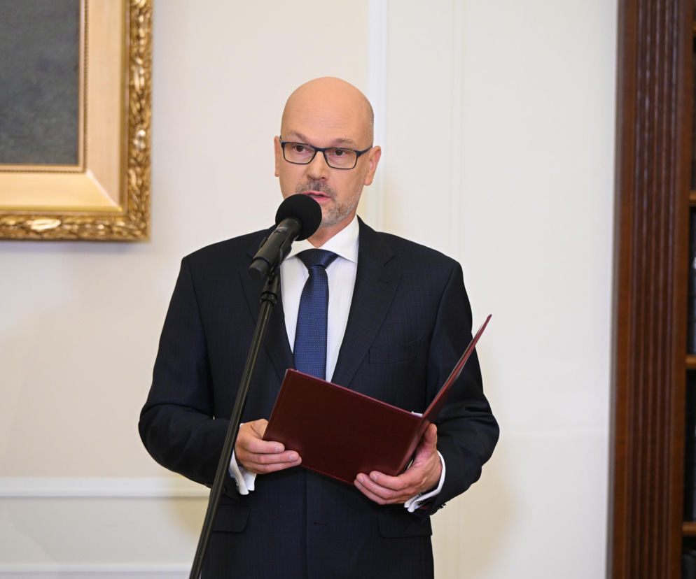 Maciej Berek składa ślubowanie przy mikrofonie, trzymając bordowy folder. O uroczystości w Sejmie przeczytasz na SE Polityka.