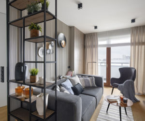Ażurowy regał w stylu loft stanowi oryginalne przepierzenie pomiędzy kuchnią a salonem.
