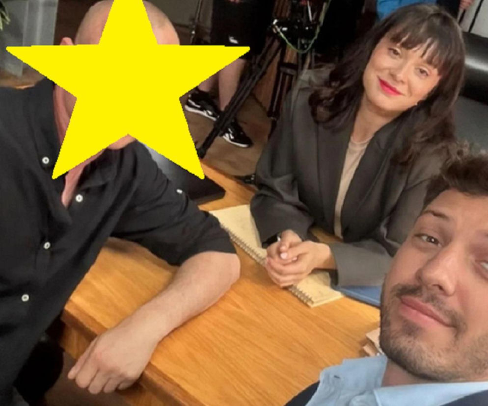 Selfie z planu serialu Barwy szczęścia, na którym Mateusz Burdach z ogoloną głową i Maria Dejmek w szarej marynarce uśmiechają się do Jaspera Sołtysiewicza, robiącego zdjęcie. Możesz przeczytać więcej o zaskakującym powrocie Sergiusza i metamorfozie aktora na Super Seriale.