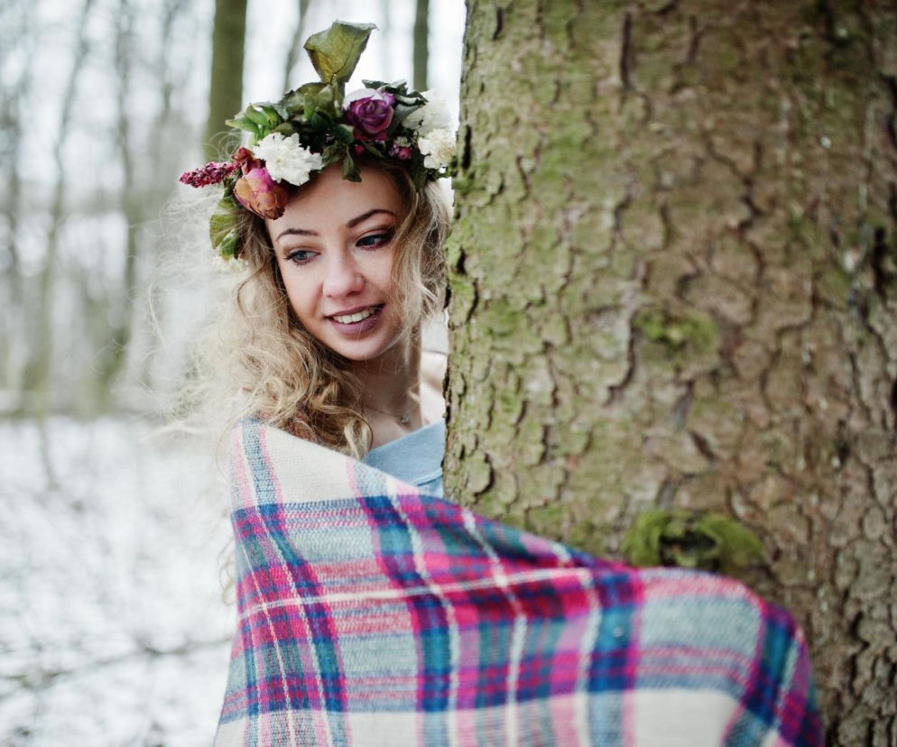 de girl with wreath in checkered plaid at snowy forest in winter day