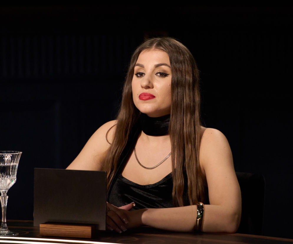 Prowadząca program The Traitors Malwina Wędzikowska przy stole. Rozwiąż psychotest na stronie VOX FM.