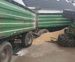 Groźna kolizja w Dąbczu. Traktor z przyczepami wjechał w dom i przewrócił się