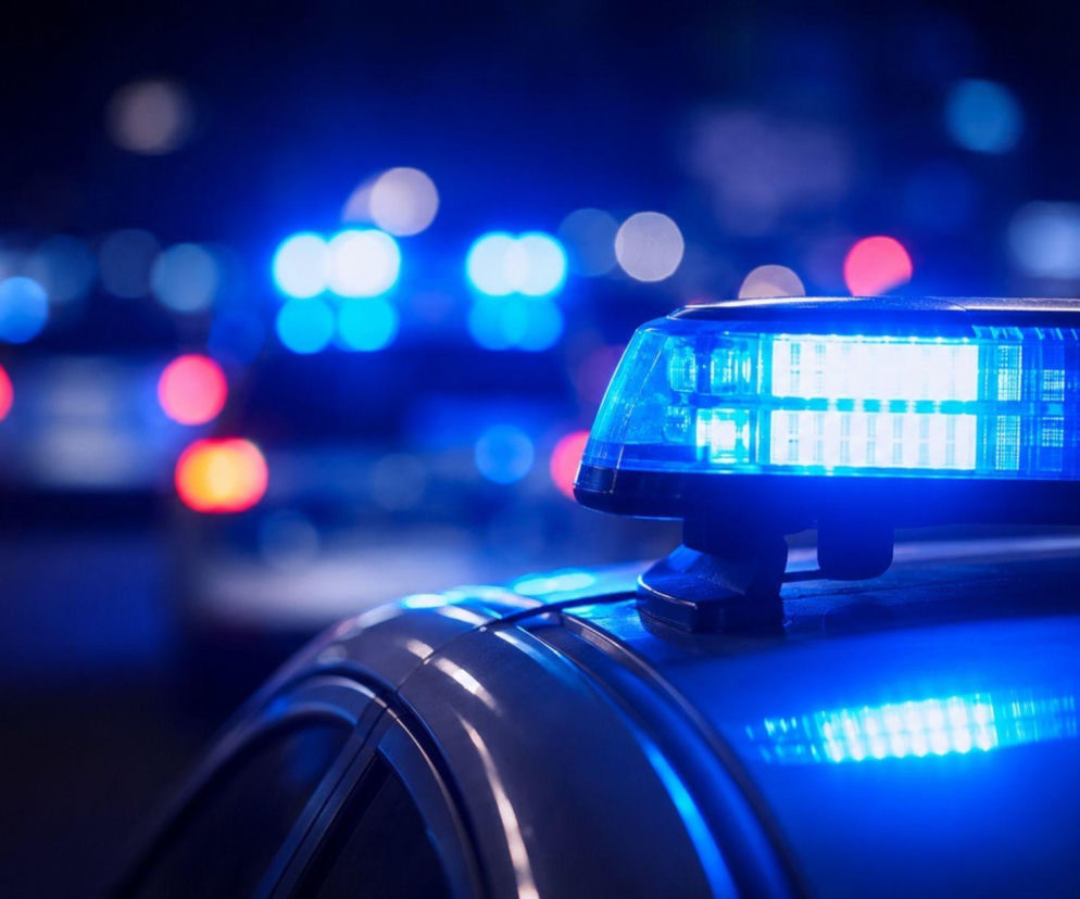 Włączone niebieskie sygnały świetlne radiowozu w nocy. O pościgu policji w Koninie przeczytasz w serwisie Eska2.