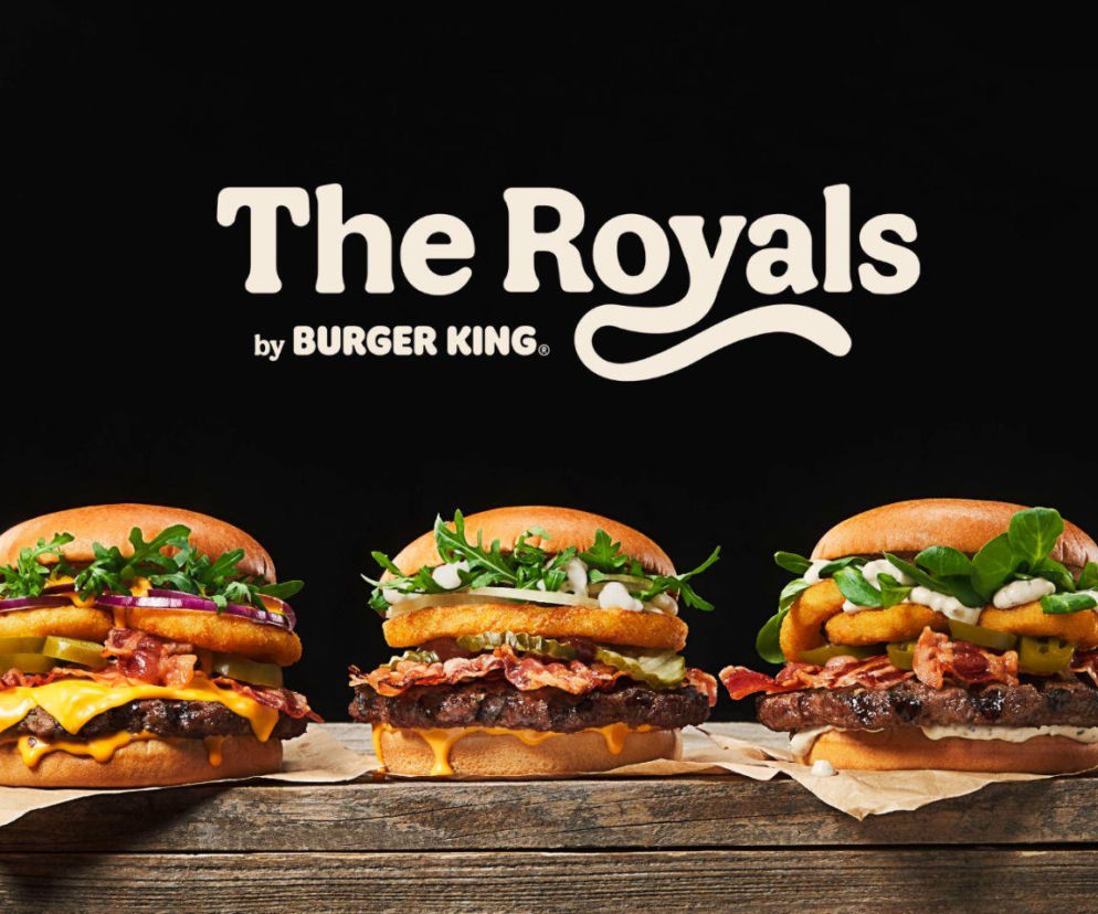 Trzy burgery premium na drewnianym blacie pod logotypem The Royals by Burger King. O nowym menu przeczytasz na Eska.