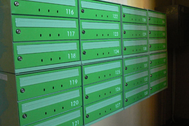 Zielone, metalowe skrzynki pocztowe z numerami od 116 do 139, wskazujące na wiele mieszkań. Skrzynki są zamknięte na klucz. Obraz odnosi się do problemu wezwań do zapłaty i tego, jak ich uniknąć, o czym możesz przeczytać na Super Biznes.