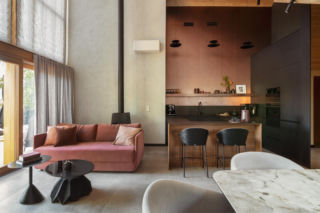 Kominek, beton, miedź i… pudrowy róż. Eklektyczny dom na Mazurach